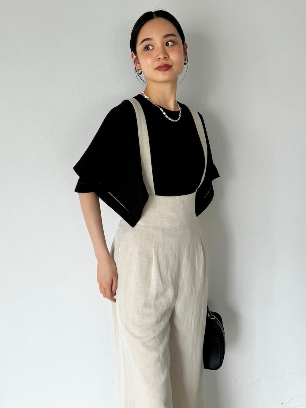 ベージュ系のその他パンツ、ブラック系のシャツ/ブラウス、ブラック系のサンダルを着用したレディースの夏コーディネートの3枚目の写真