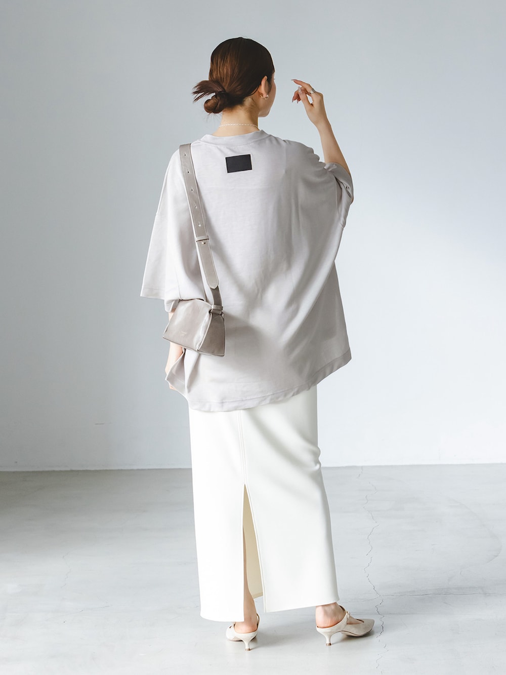 ベージュ系のTシャツ/カットソー、ホワイト系のスカート、グレー系のショルダーバッグを着用したレディースの春コーディネートの3枚目の写真