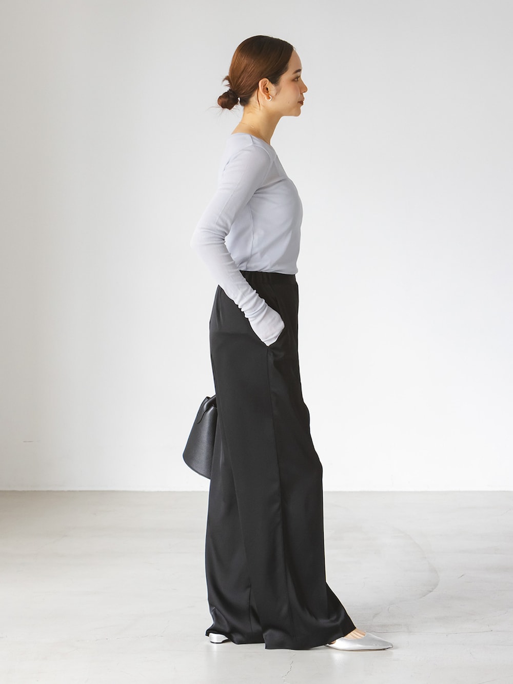 ブルー系のTシャツ/カットソー、ブラック系のスラックス、ブラック系のショルダーバッグを着用したレディースの春コーディネートの2枚目の写真