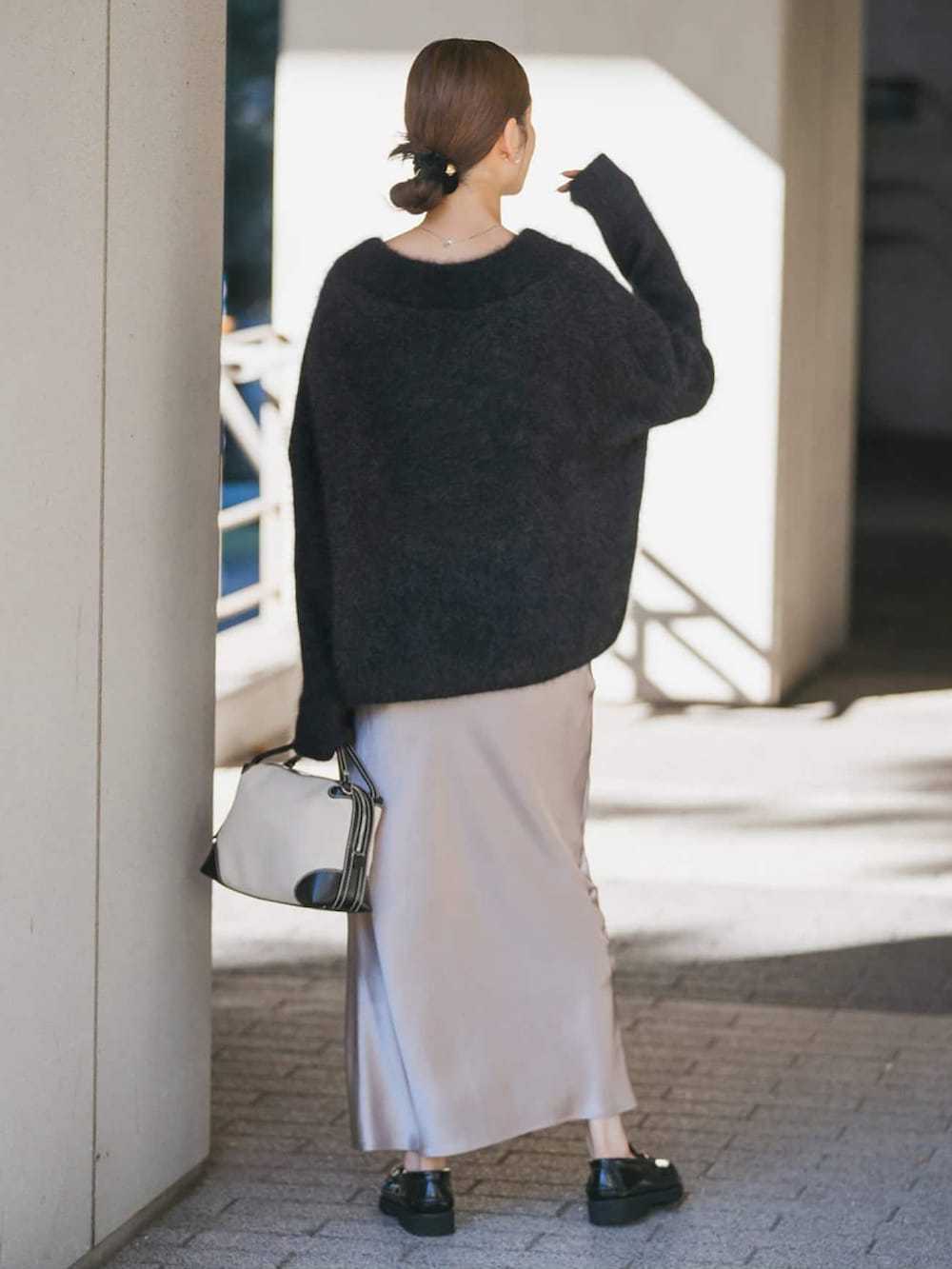 グレー系のニット/セーター、ブラック系のローファー、ブラック系のショルダーバッグを着用したレディースの冬コーディネートの2枚目の写真