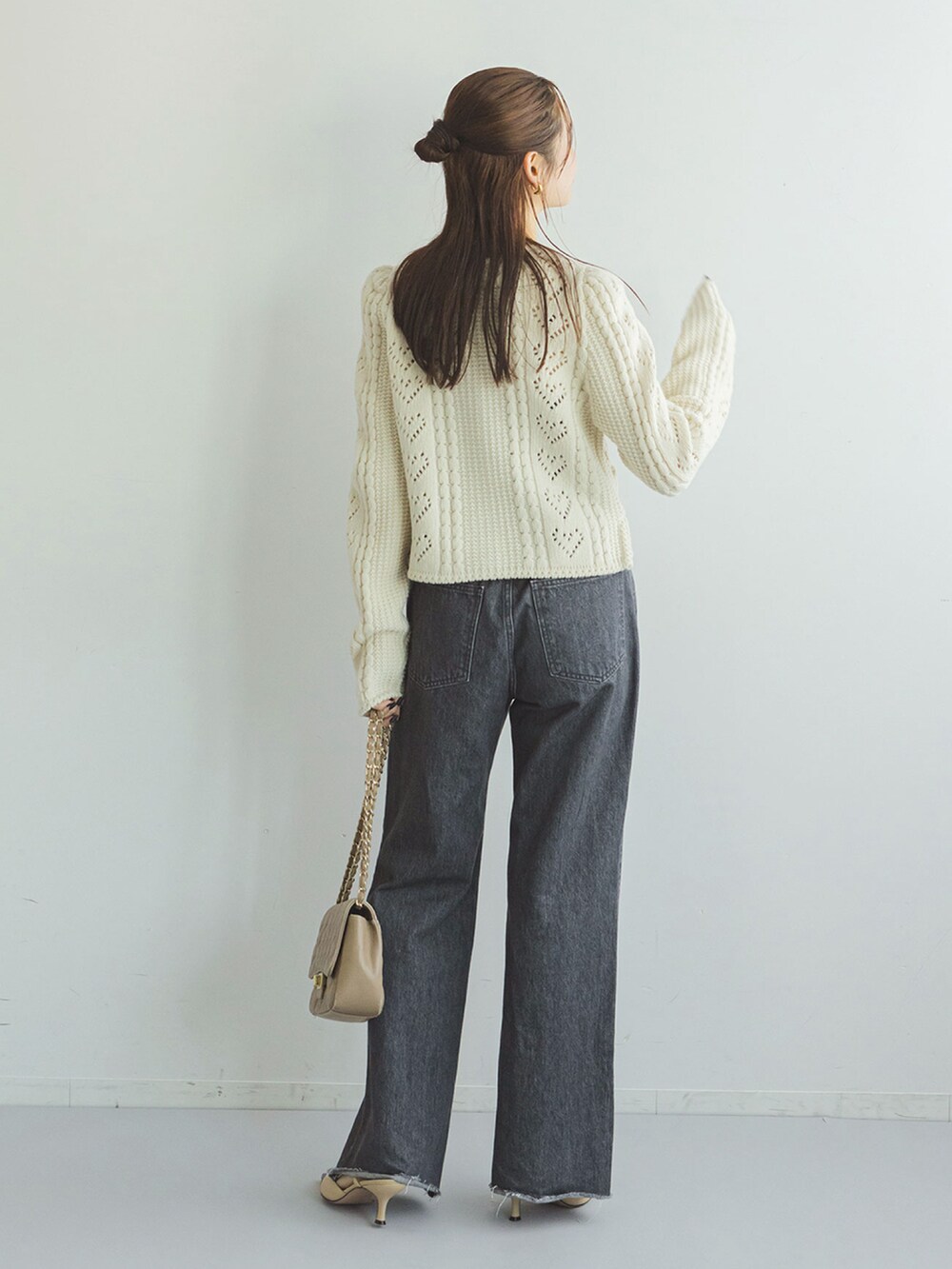 ホワイト系のカーディガン/ボレロ、ブラック系のデニムパンツ、ベージュ系のショルダーバッグを着用したレディースの秋コーディネートの3枚目の写真