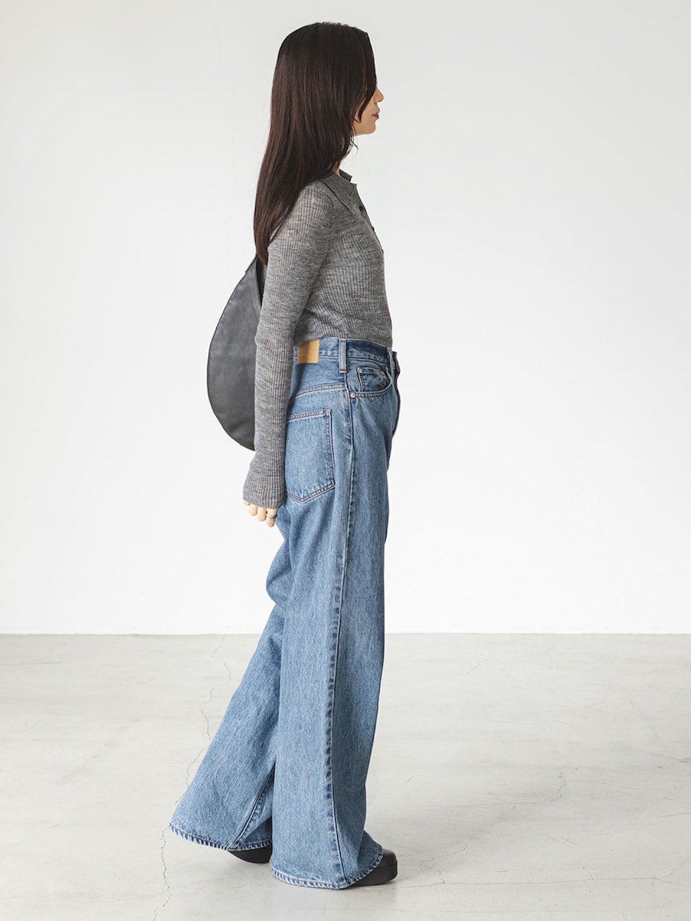 ブルー系のデニムパンツ、グレー系のニット/セーターを着用したレディースの秋コーディネートの2枚目の写真