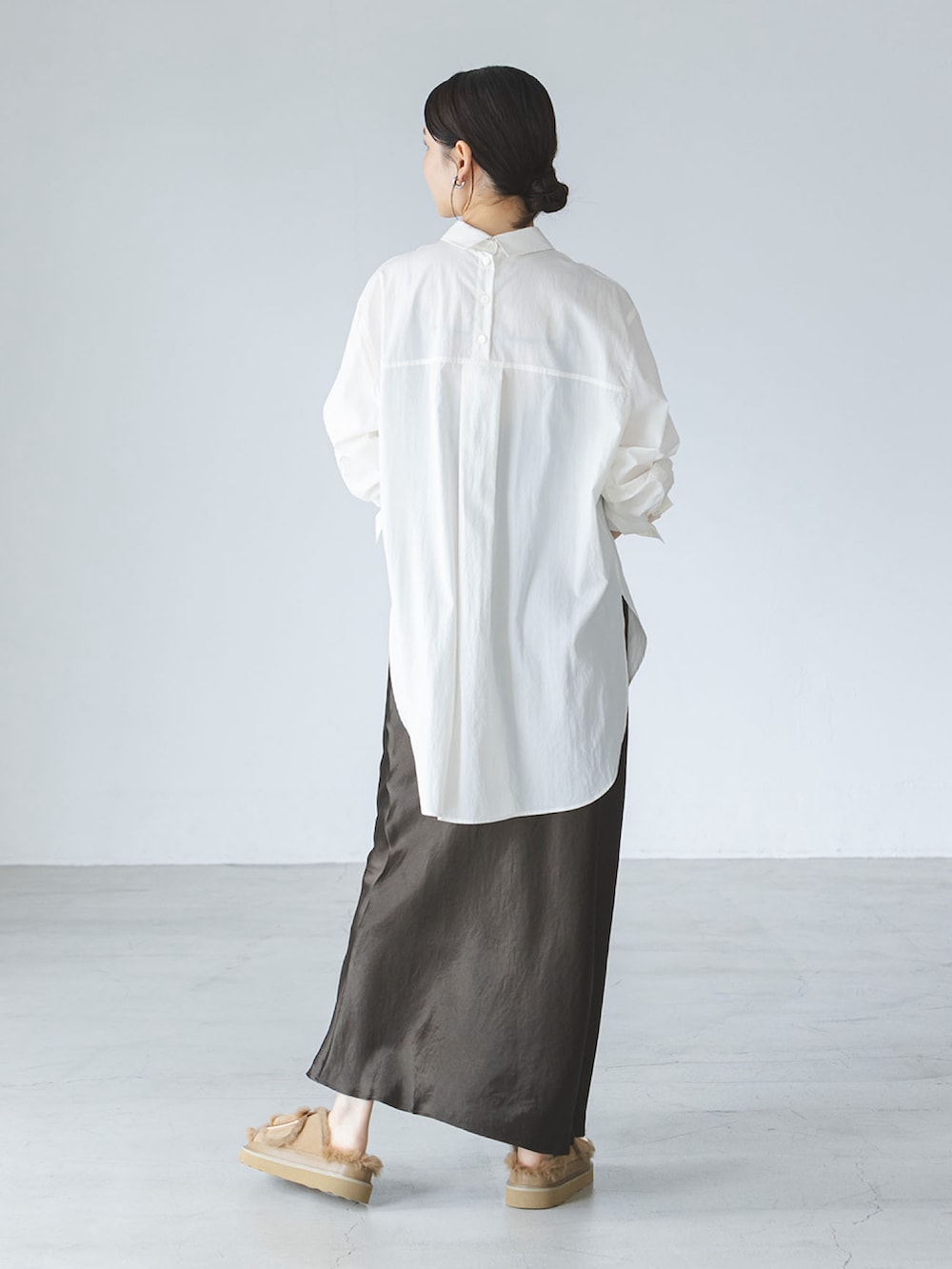 ブラウン系のスカート、ベージュ系のサンダル、ホワイト系のシャツ/ブラウスを着用したレディースの夏コーディネートの2枚目の写真