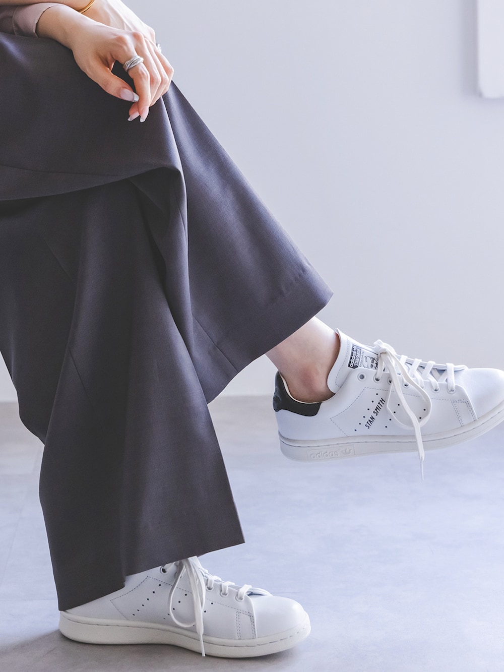 グレー系のスラックス、ピンク系のシャツ/ブラウス、ホワイト系のスニーカーを着用したレディースの春コーディネートの2枚目の写真