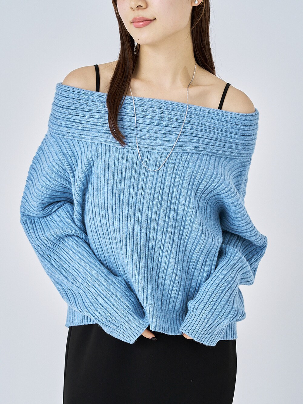 ブルー系のニット/セーター、ブラック系のワンピース、ブラック系のパンプスを着用したレディースの冬コーディネートの3枚目の写真