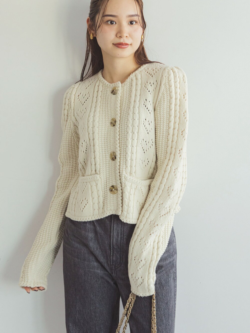 ホワイト系のカーディガン/ボレロ、ブラック系のデニムパンツ、ベージュ系のショルダーバッグを着用したレディースの秋コーディネートの4枚目の写真