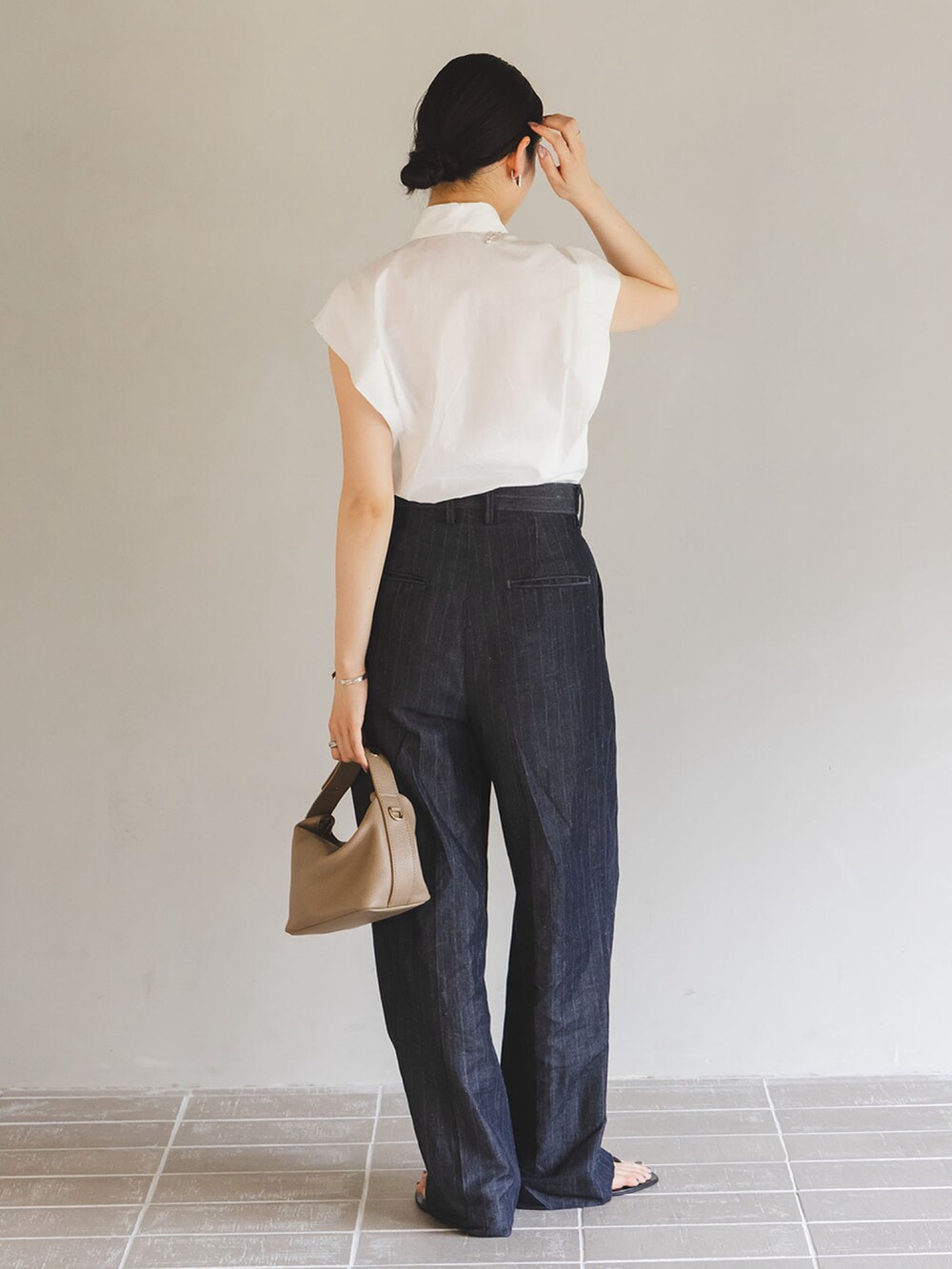 ホワイト系のシャツ/ブラウス、ブルー系のスラックス、ベージュ系のショルダーバッグを着用したレディースの夏コーディネートの3枚目の写真
