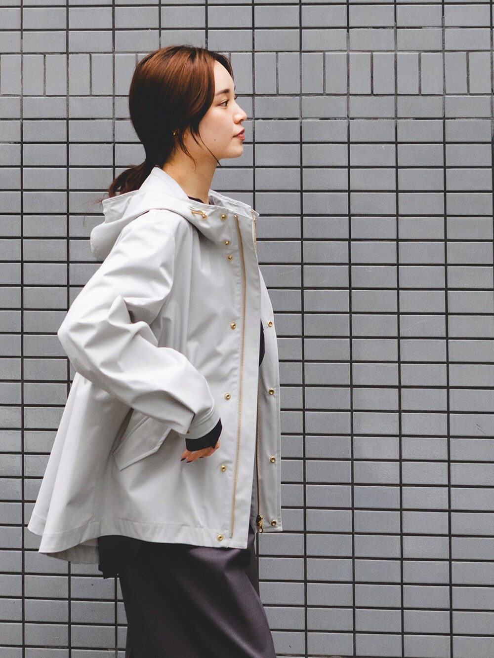 グレー系のマウンテンパーカー、ブルー系のシャツ/ブラウス、グレー系のスラックスを着用したレディースの冬コーディネートの3枚目の写真