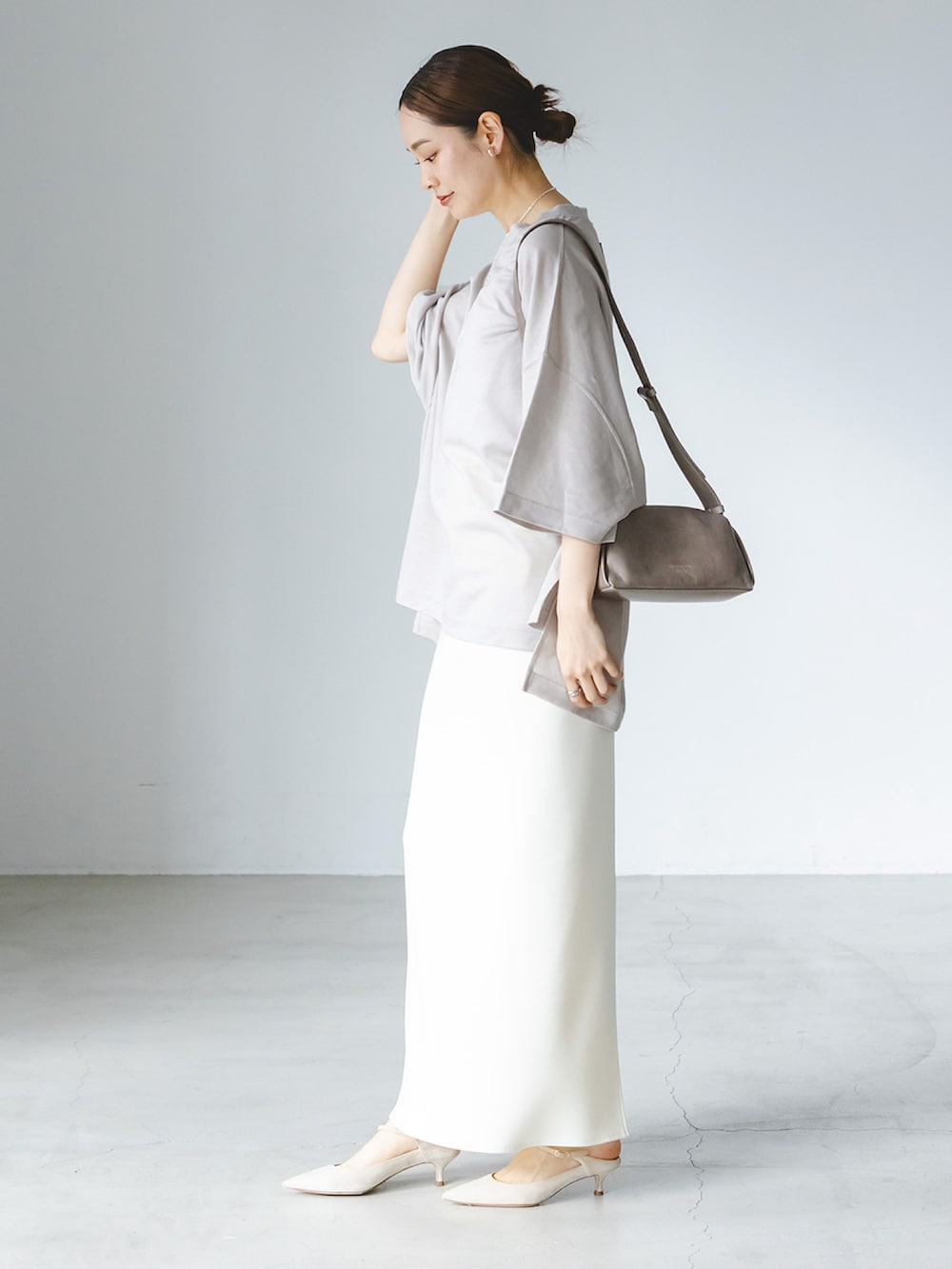 ベージュ系のTシャツ/カットソー、ホワイト系のスカート、グレー系のショルダーバッグを着用したレディースの春コーディネートの2枚目の写真