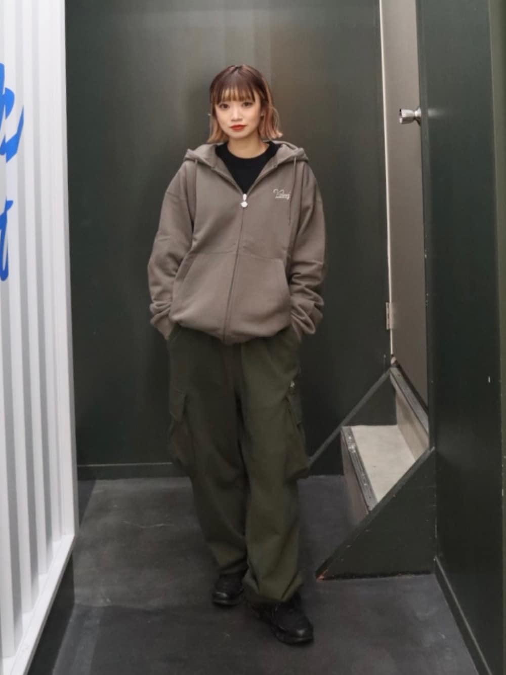 グレー系のパーカー、グリーン系のスウェットパンツ、ブラック系のTシャツ/カットソーを着用したレディースの秋コーディネートの4枚目の写真