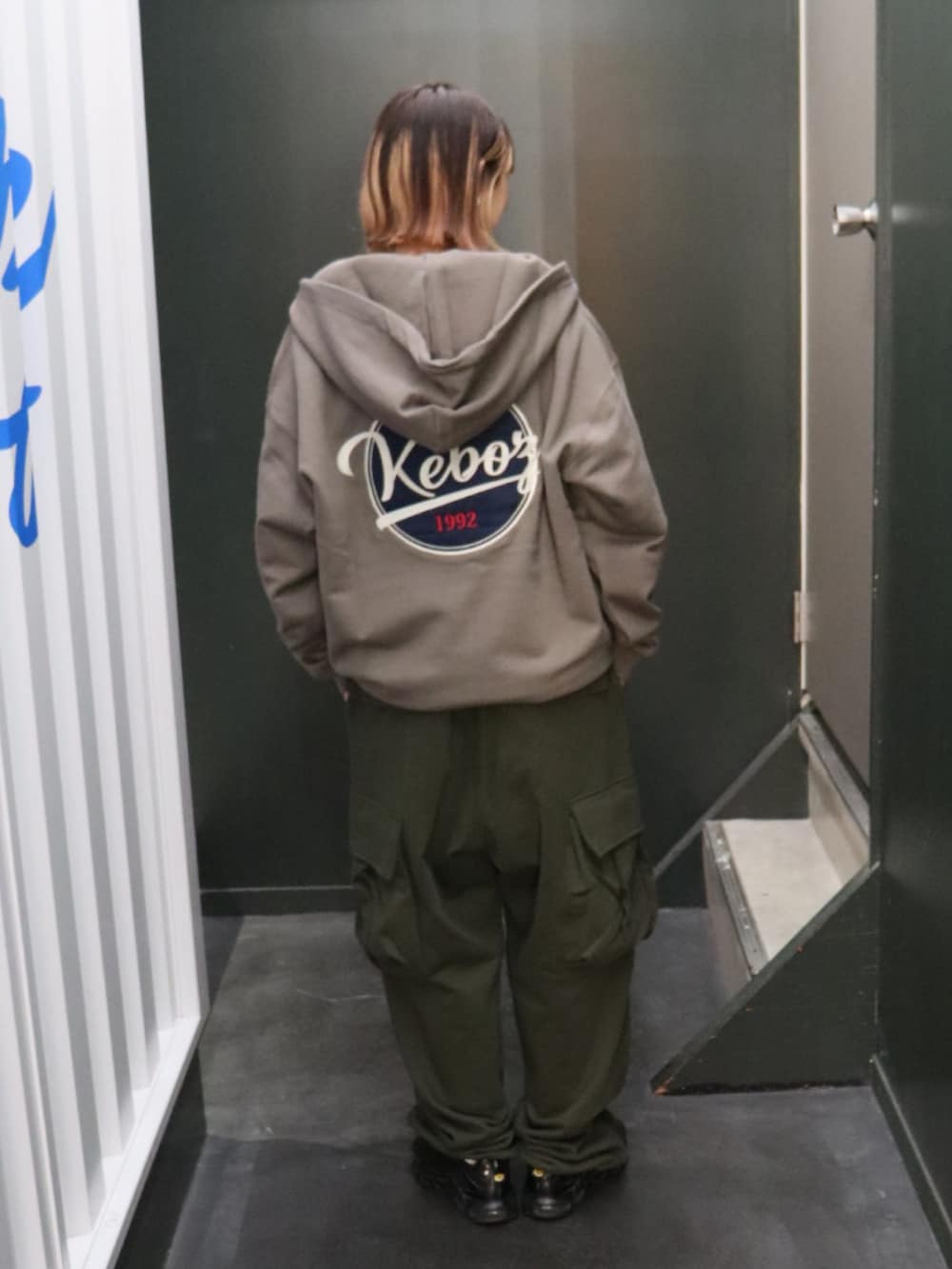 グレー系のパーカー、グリーン系のスウェットパンツ、ブラック系のTシャツ/カットソーを着用したレディースの秋コーディネートの2枚目の写真