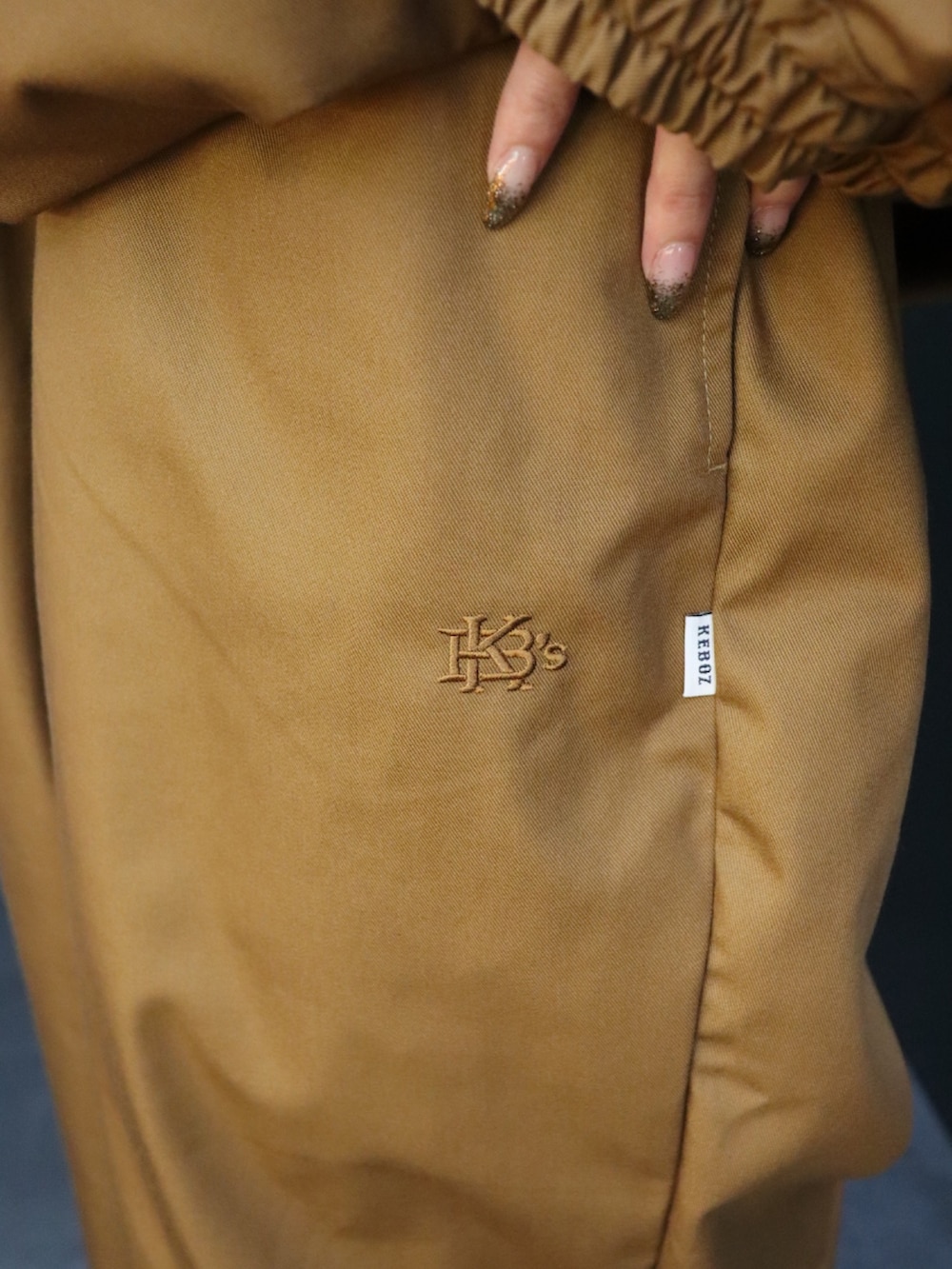 ブラウン系のナイロンジャケット、ブラウン系のその他パンツを着用したレディースの秋コーディネートの5枚目の写真