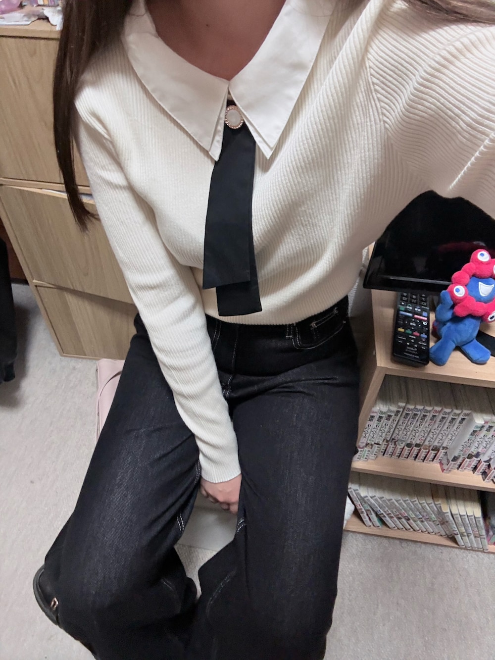 ホワイト系のニット/セーター、ブラック系のデニムパンツを着用したレディースの秋コーディネートの2枚目の写真