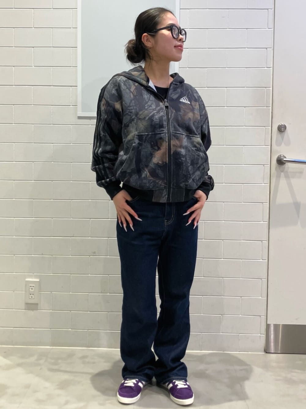 ブラック系のパーカー、パープル系のスニーカーを着用したレディースの秋コーディネートの2枚目の写真