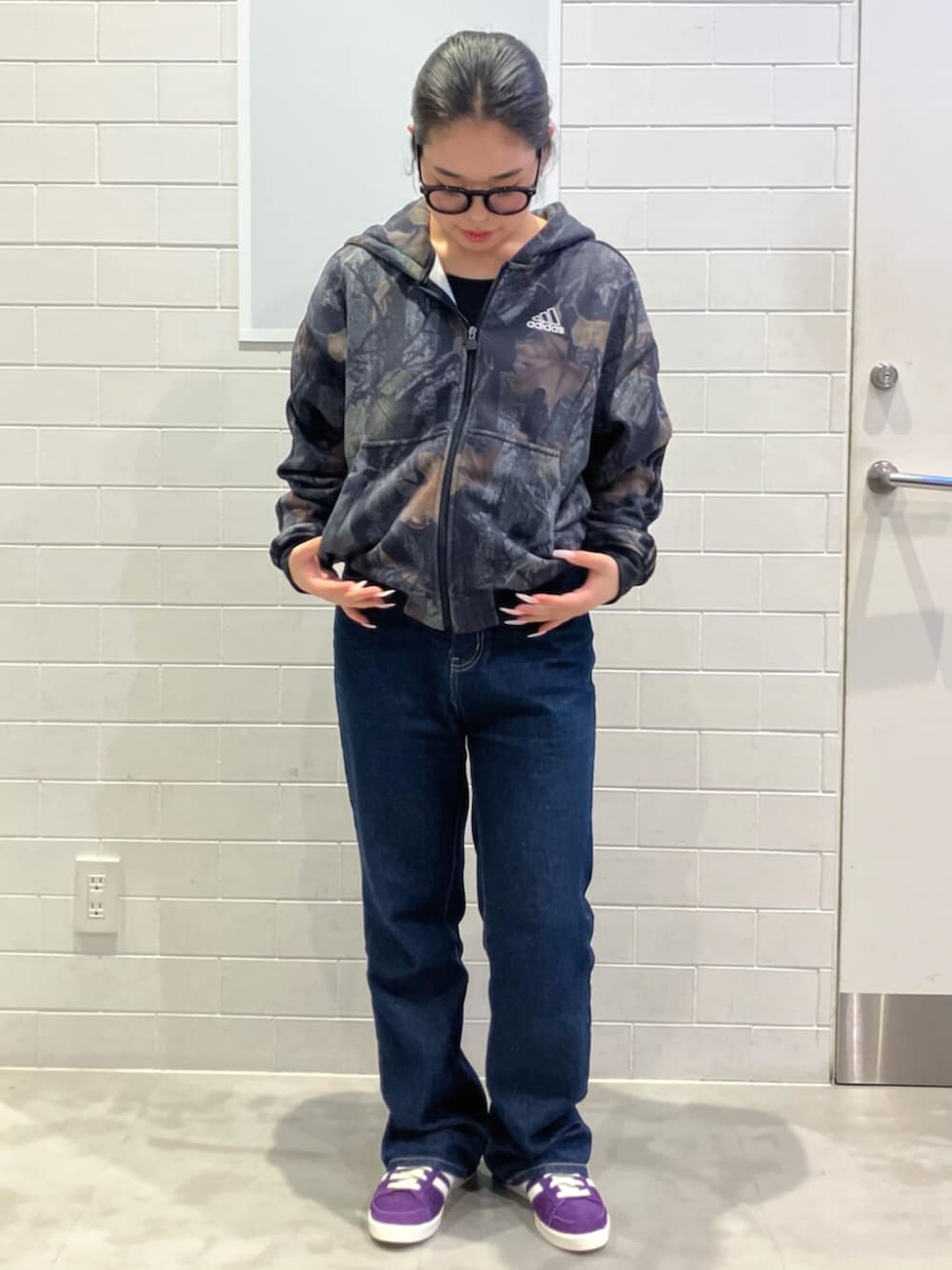 ブラック系のパーカー、パープル系のスニーカーを着用したレディースの秋コーディネートの4枚目の写真