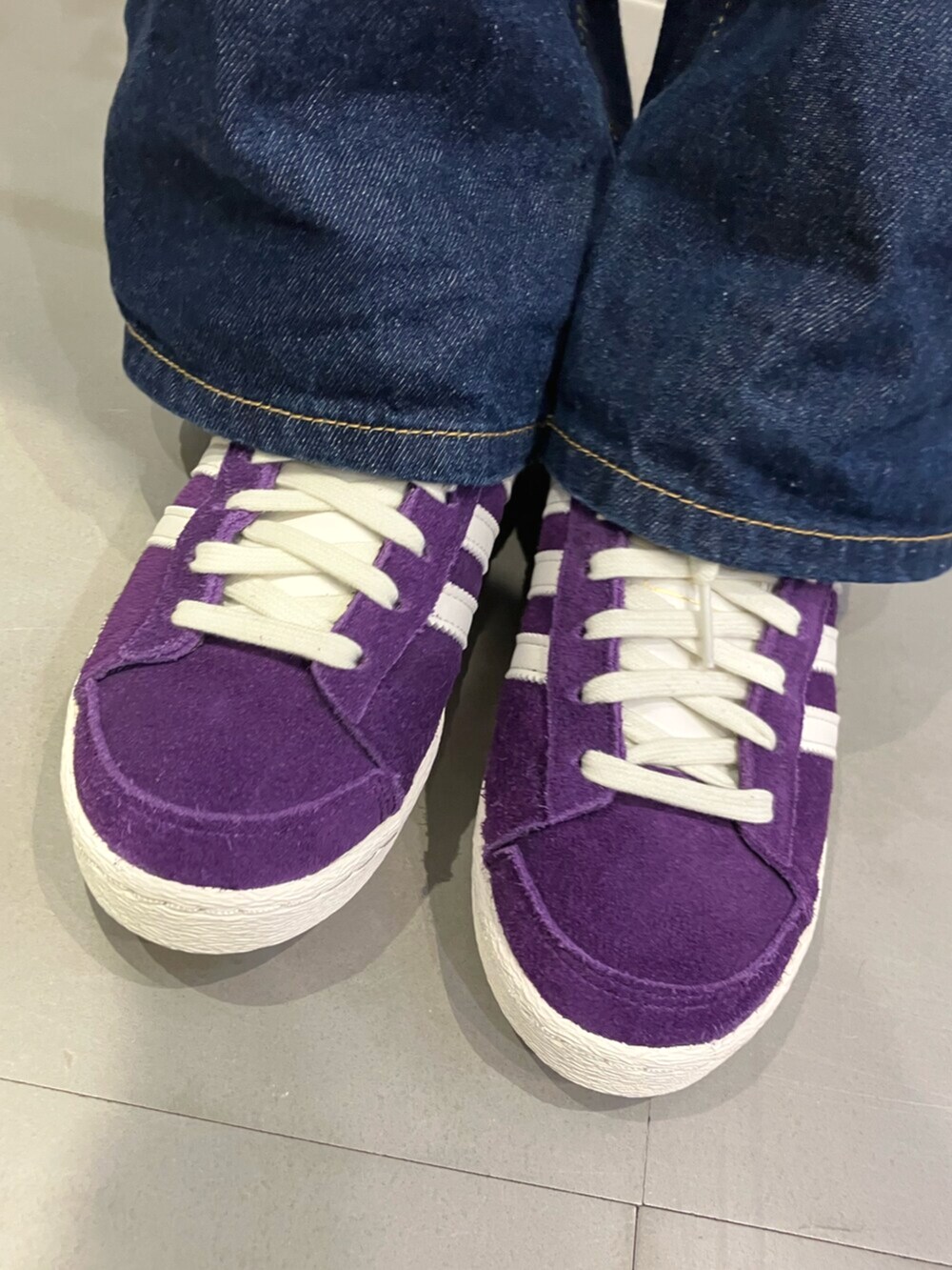 ブラック系のパーカー、パープル系のスニーカーを着用したレディースの秋コーディネートの6枚目の写真