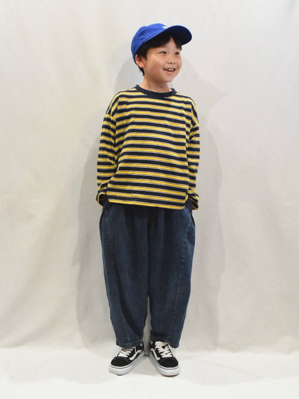 ブラック系のスニーカー、ブルー系のデニムパンツ、ブルー系のTシャツ/カットソーを着用したキッズの春コーディネートの3枚目の写真