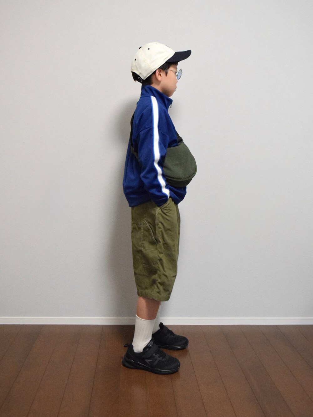 グリーン系のショルダーバッグ、ブルー系のジャージ、グリーン系のパンツを着用したキッズの夏コーディネートの2枚目の写真