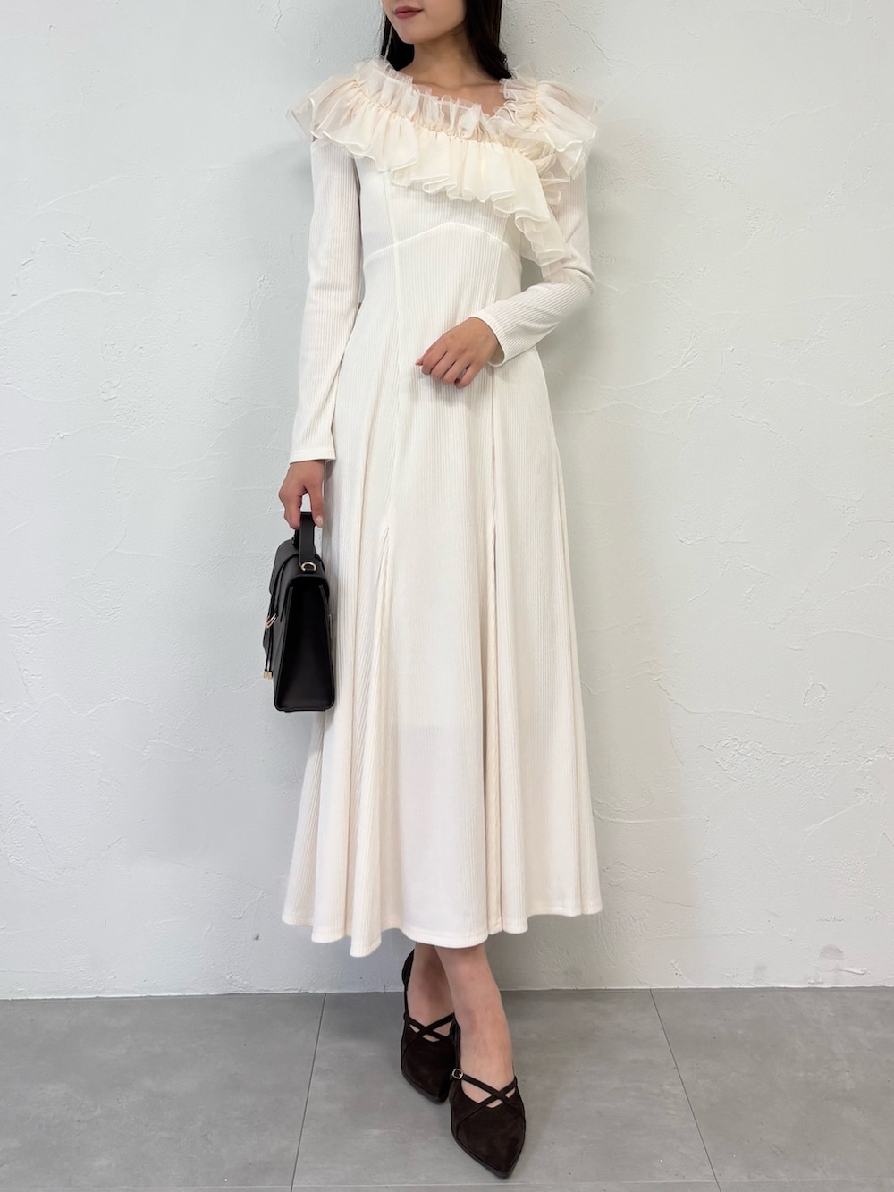 ブラウン系のショルダーバッグ、ブラウン系のパンプス、ホワイト系のワンピースを着用したレディースの秋コーディネートの2枚目の写真