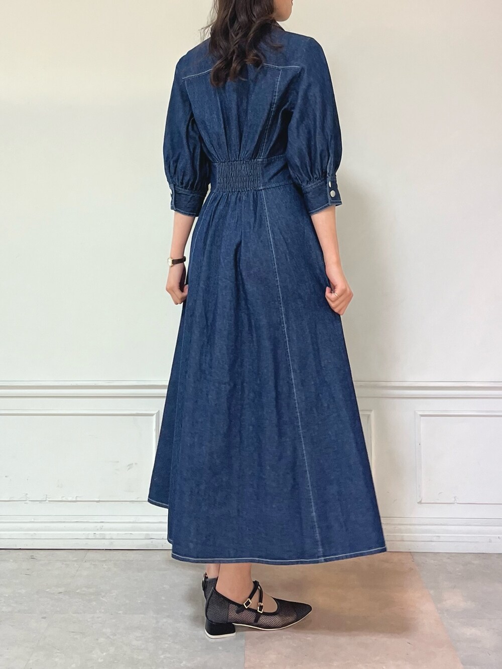 ブルー系のワンピース、ブラック系のパンプスを着用したレディースの冬コーディネートの4枚目の写真