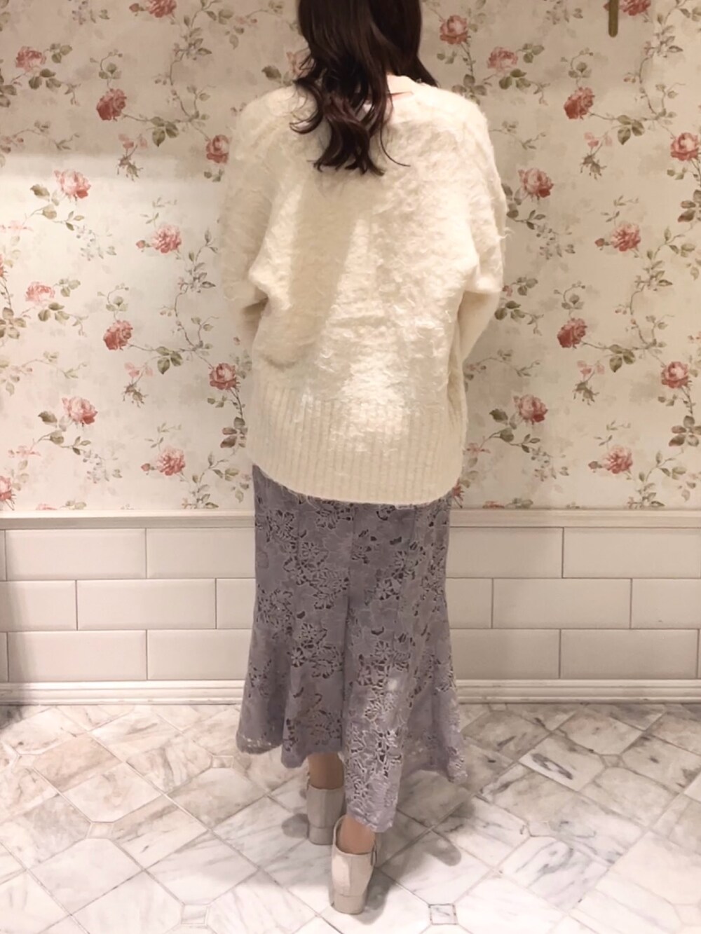 ホワイト系のカーディガン/ボレロ、ホワイト系のニット/セーター、グレー系のスカートを着用したレディースの冬コーディネートの5枚目の写真