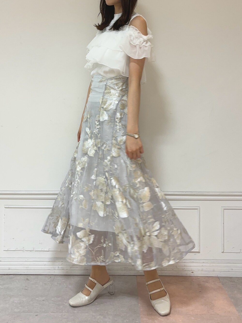 ホワイト系のTシャツ/カットソー、グレー系のスカート、ホワイト系のパンプスを着用したレディースの夏コーディネートの2枚目の写真