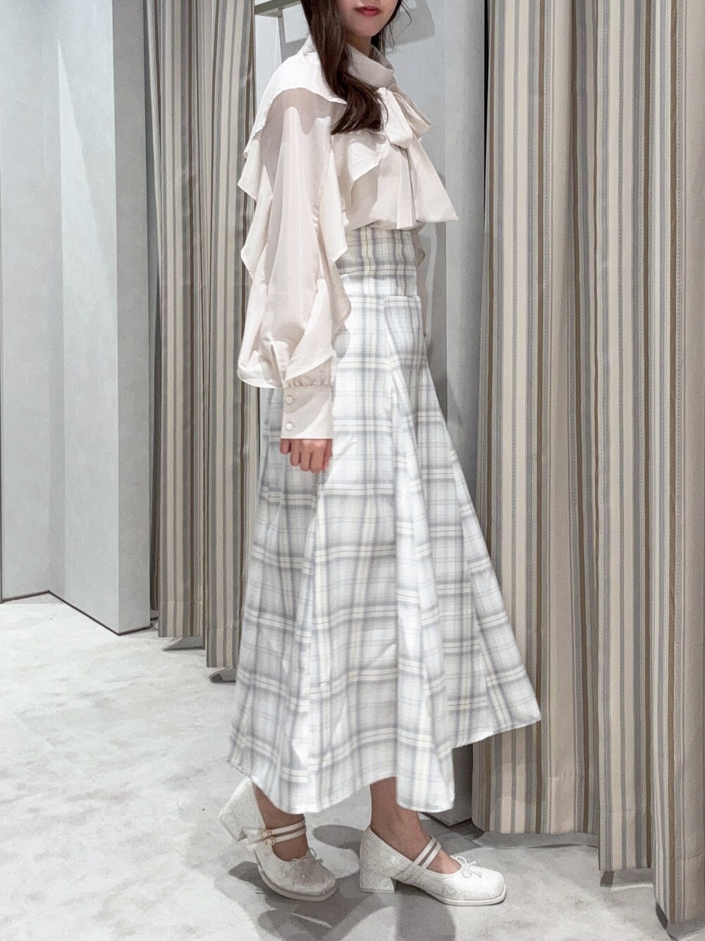 ホワイト系のシャツ/ブラウス、イエロー系のスカート、ホワイト系のバレエシューズを着用したレディースの春コーディネートの3枚目の写真