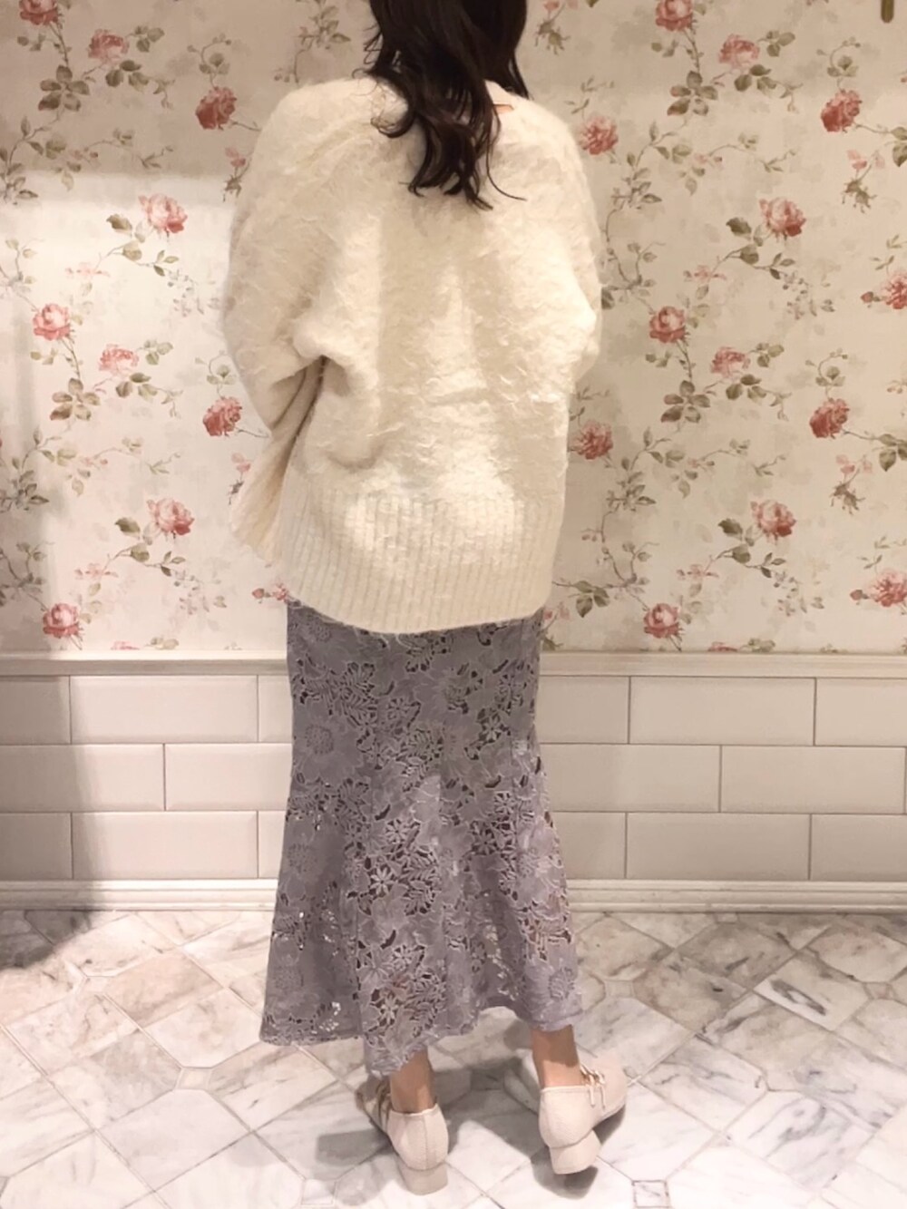 ホワイト系のカーディガン/ボレロ、ホワイト系のニット/セーター、グレー系のスカートを着用したレディースの冬コーディネートの4枚目の写真