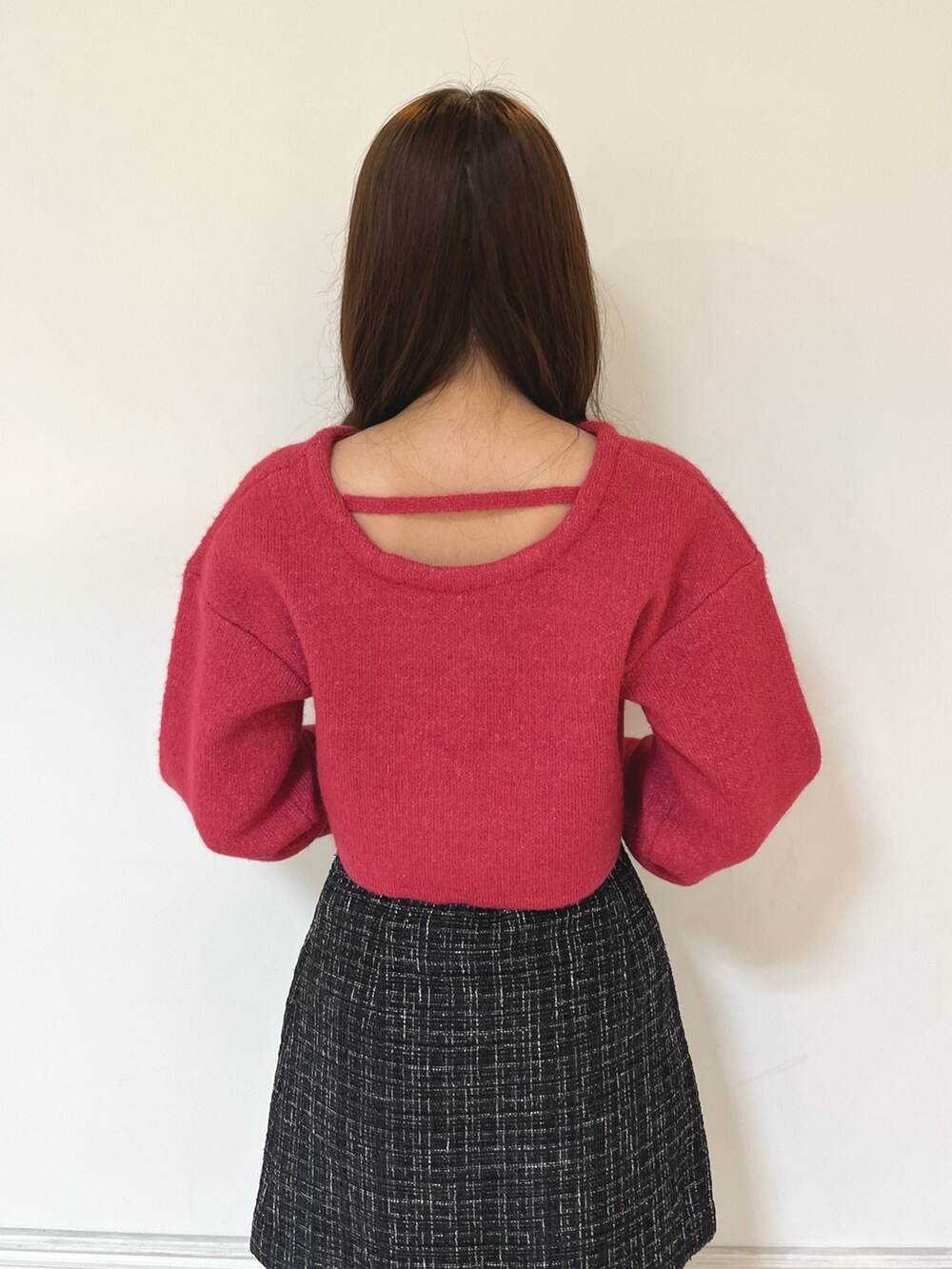 ブラック系のブーツ、ブラック系のスカート、レッド系のニット/セーターを着用したレディースの秋コーディネートの5枚目の写真