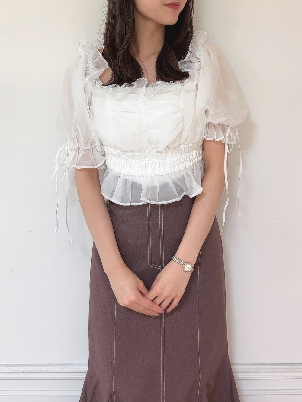 ブラウン系のスカート、ホワイト系のシャツ/ブラウス、ベージュ系のパンプスを着用したレディースの秋コーディネートの4枚目の写真