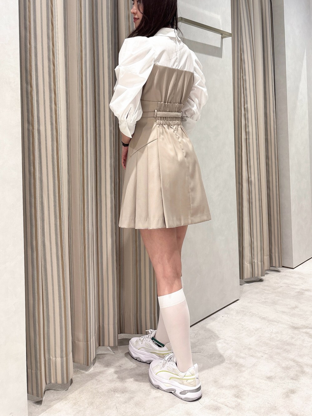 ベージュ系のワンピース、ホワイト系のスニーカーを着用したレディースの春コーディネートの4枚目の写真