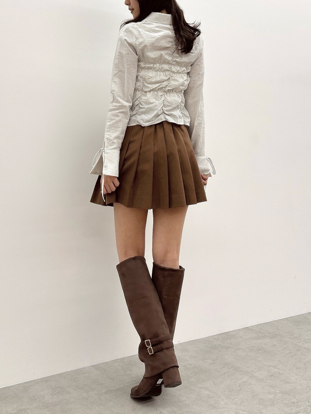 ブルー系のシャツ/ブラウス、イエロー系のスカート、ブラウン系のブーツを着用したレディースの春コーディネートの4枚目の写真