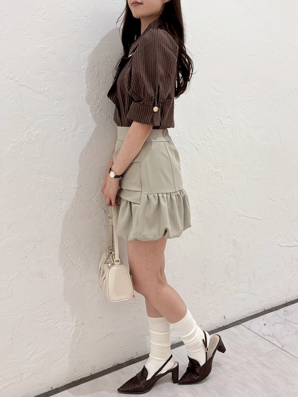 ブラウン系のシャツ/ブラウス、ベージュ系のスカート、ブラウン系のローファーを着用したレディースの夏コーディネートの5枚目の写真