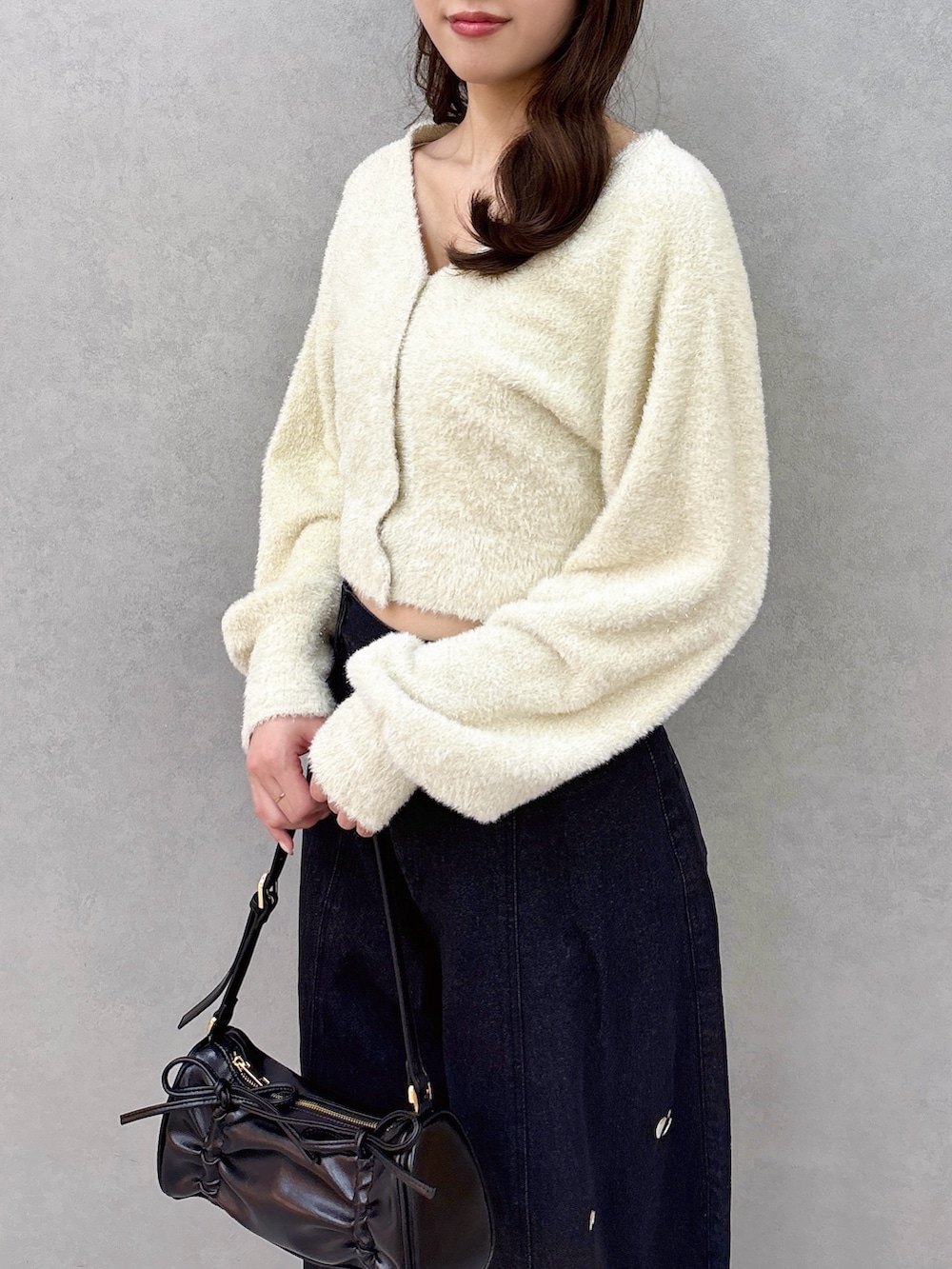 ベージュ系のカーディガン/ボレロ、ブルー系のデニムパンツ、ブラック系のパンプスを着用したレディースの冬コーディネートの7枚目の写真