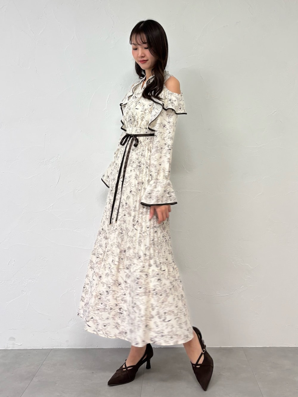 ブラウン系のパンプス、ホワイト系のワンピースを着用したレディースの夏コーディネートの3枚目の写真