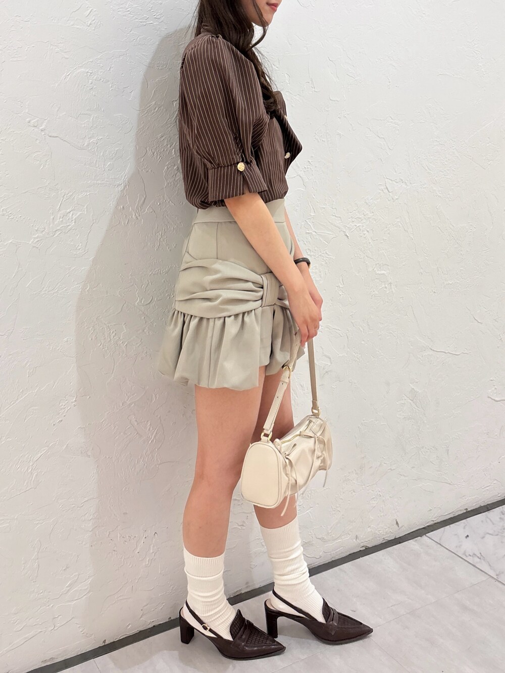 ブラウン系のシャツ/ブラウス、ベージュ系のスカート、ブラウン系のローファーを着用したレディースの夏コーディネートの4枚目の写真