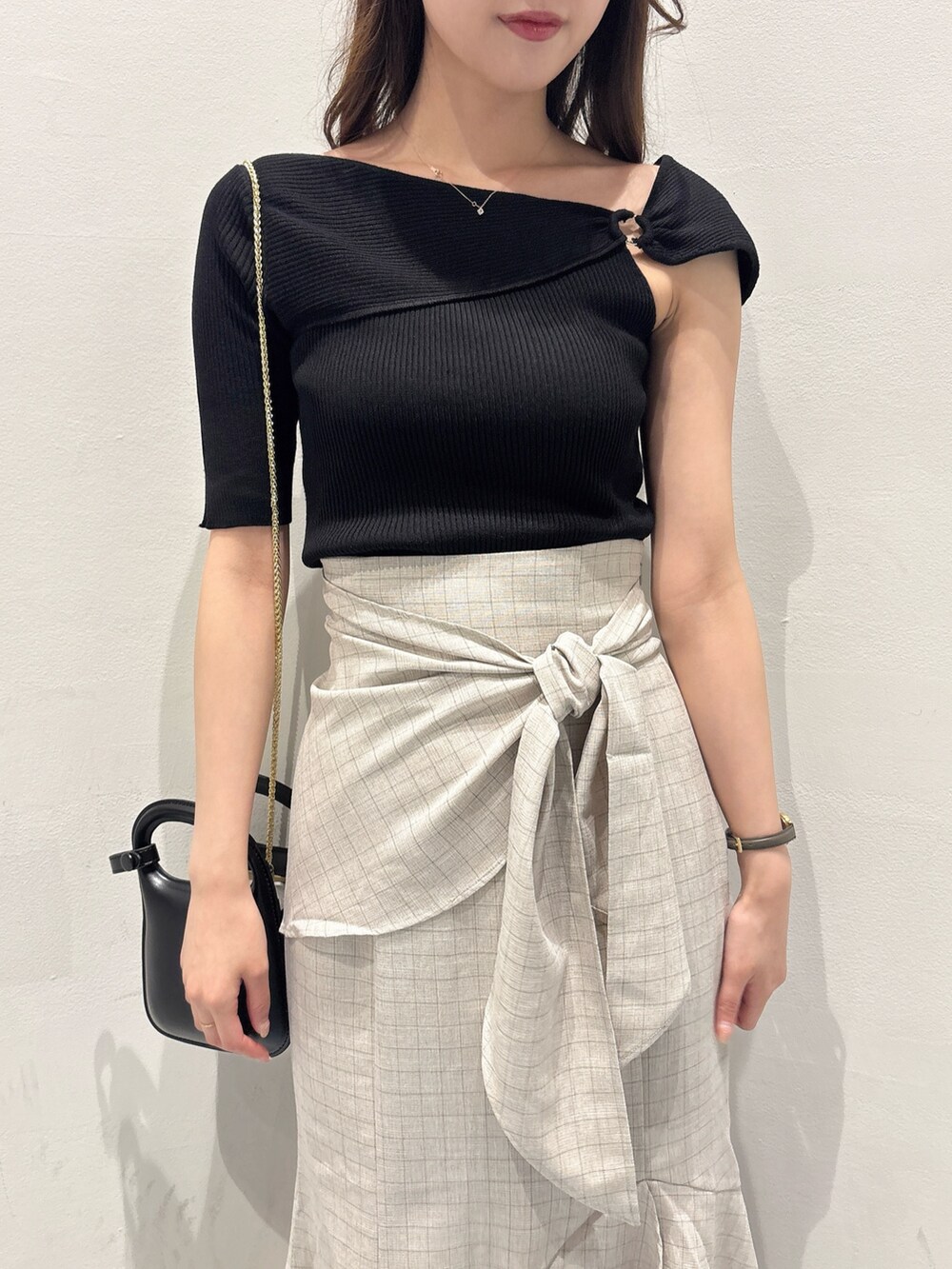 ブラック系のニット/セーター、ベージュ系のスカート、ブラック系のサンダルを着用したレディースの夏コーディネートの4枚目の写真