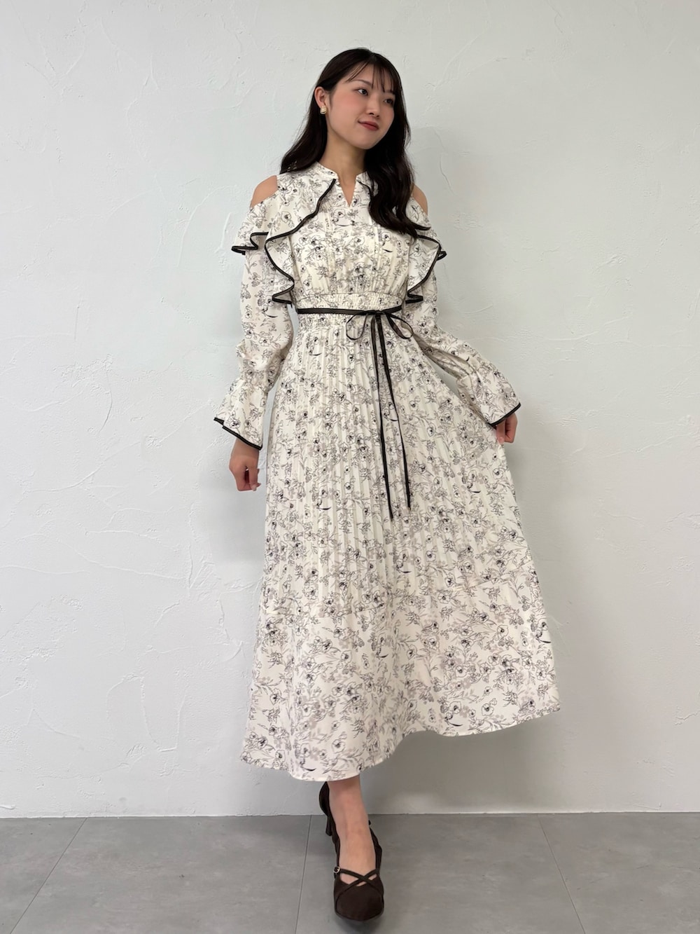 ブラウン系のパンプス、ホワイト系のワンピースを着用したレディースの夏コーディネートの2枚目の写真