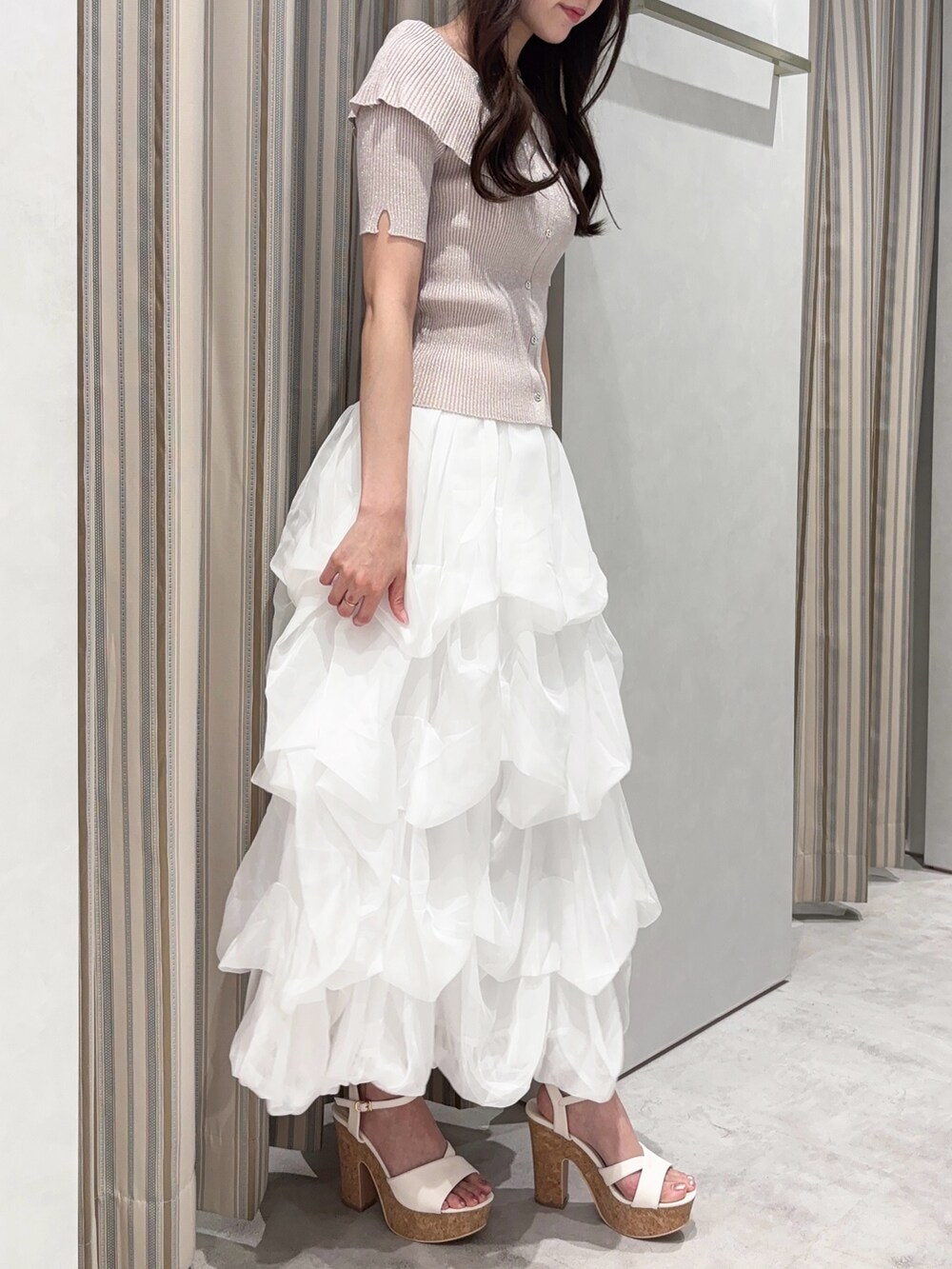 ホワイト系のスカート、ピンク系のニット/セーター、ホワイト系のサンダルを着用したレディースの夏コーディネートの3枚目の写真