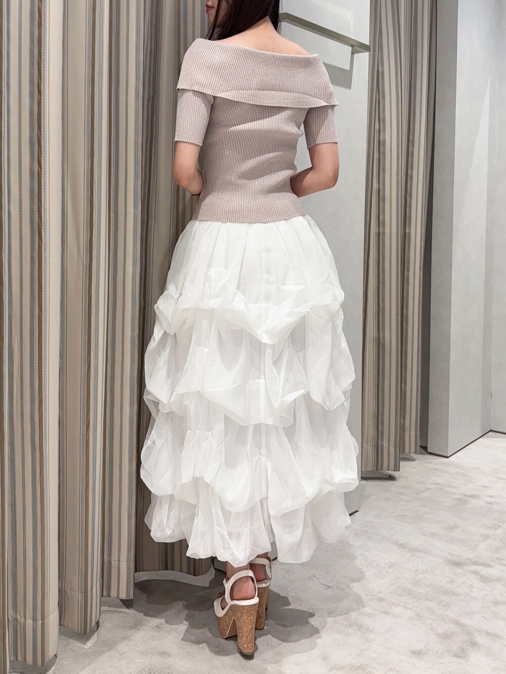 ホワイト系のスカート、ピンク系のニット/セーター、ホワイト系のサンダルを着用したレディースの夏コーディネートの4枚目の写真