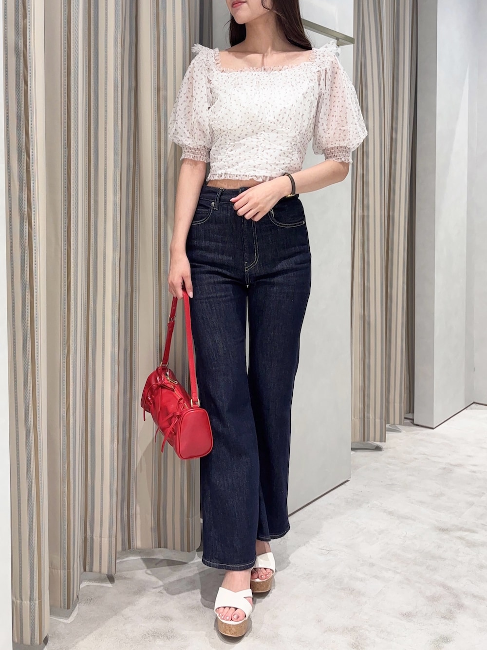 ピンク系のシャツ/ブラウス、ブルー系のデニムパンツ、レッド系のハンドバッグを着用したレディースの夏コーディネートの3枚目の写真