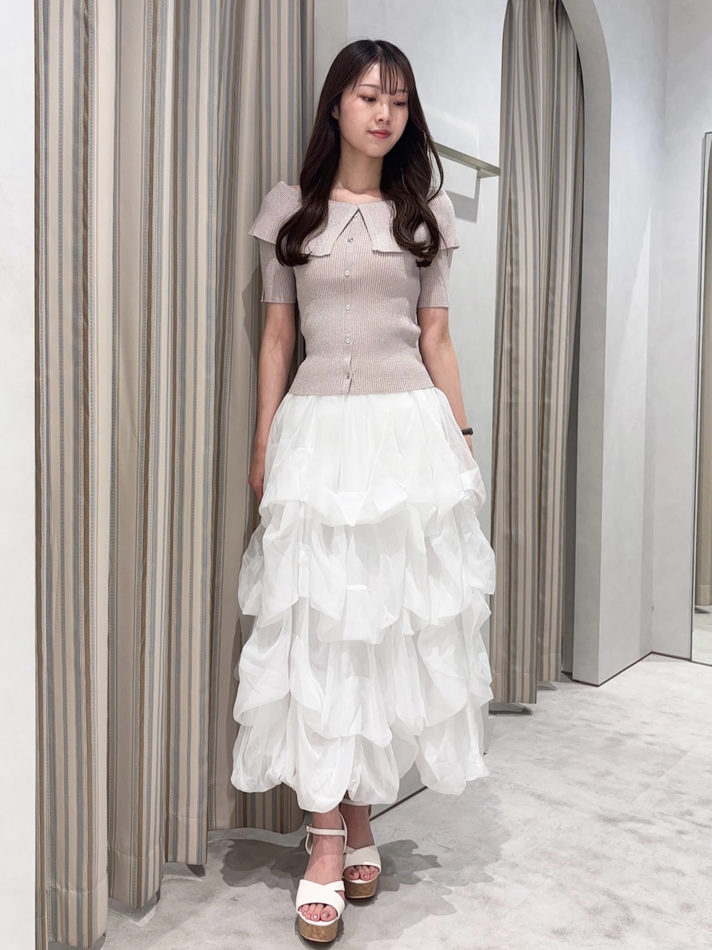 ホワイト系のスカート、ピンク系のニット/セーター、ホワイト系のサンダルを着用したレディースの夏コーディネートの2枚目の写真