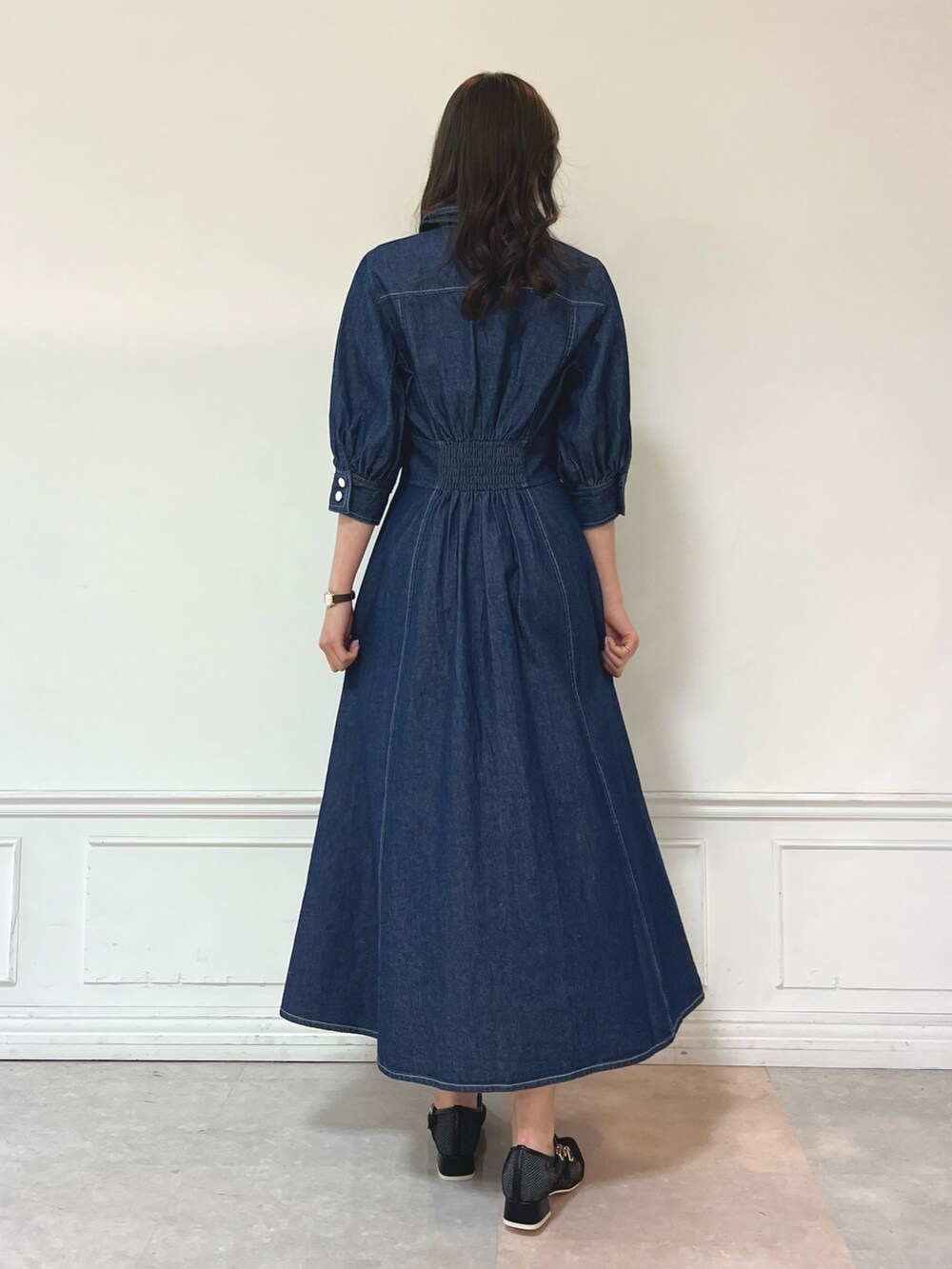 ブルー系のワンピース、ブラック系のパンプスを着用したレディースの冬コーディネートの5枚目の写真