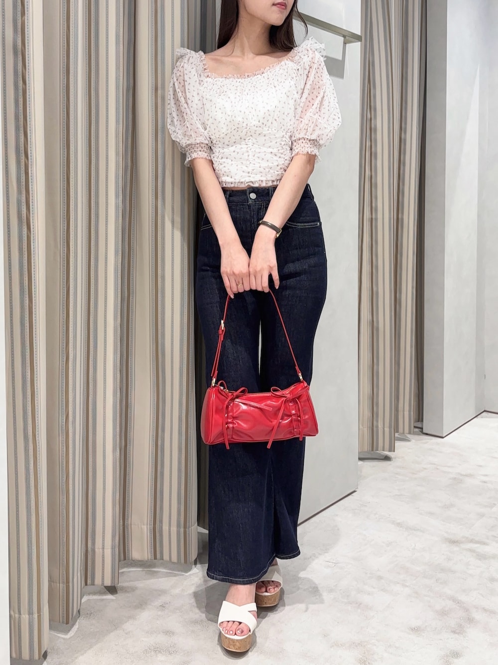 ピンク系のシャツ/ブラウス、ブルー系のデニムパンツ、レッド系のハンドバッグを着用したレディースの夏コーディネートの4枚目の写真