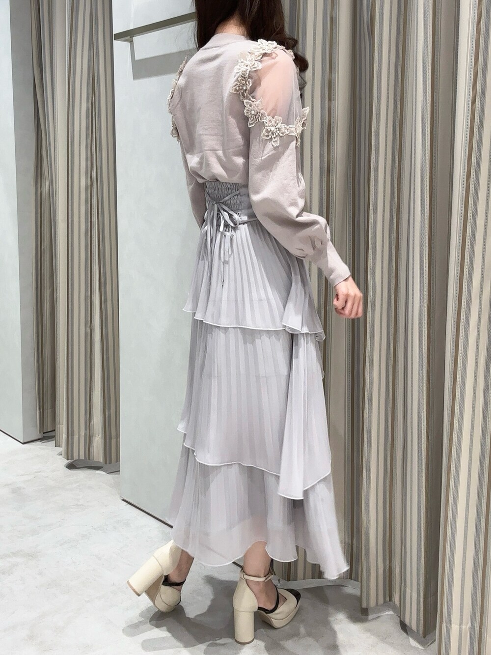 ピンク系のニット/セーター、グレー系のスカート、ベージュ系のパンプスを着用したレディースの冬コーディネートの3枚目の写真