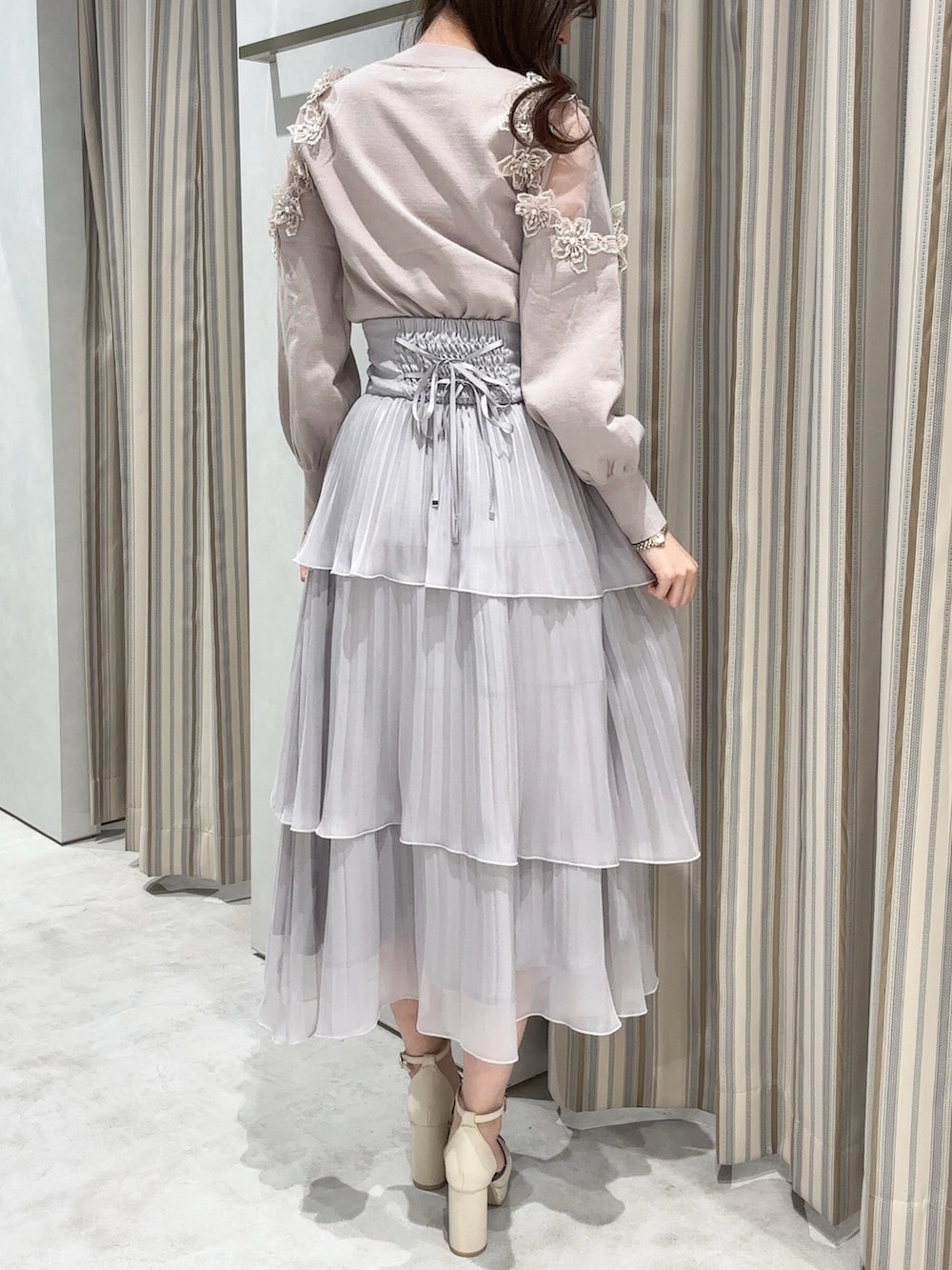 ピンク系のニット/セーター、グレー系のスカート、ベージュ系のパンプスを着用したレディースの冬コーディネートの4枚目の写真