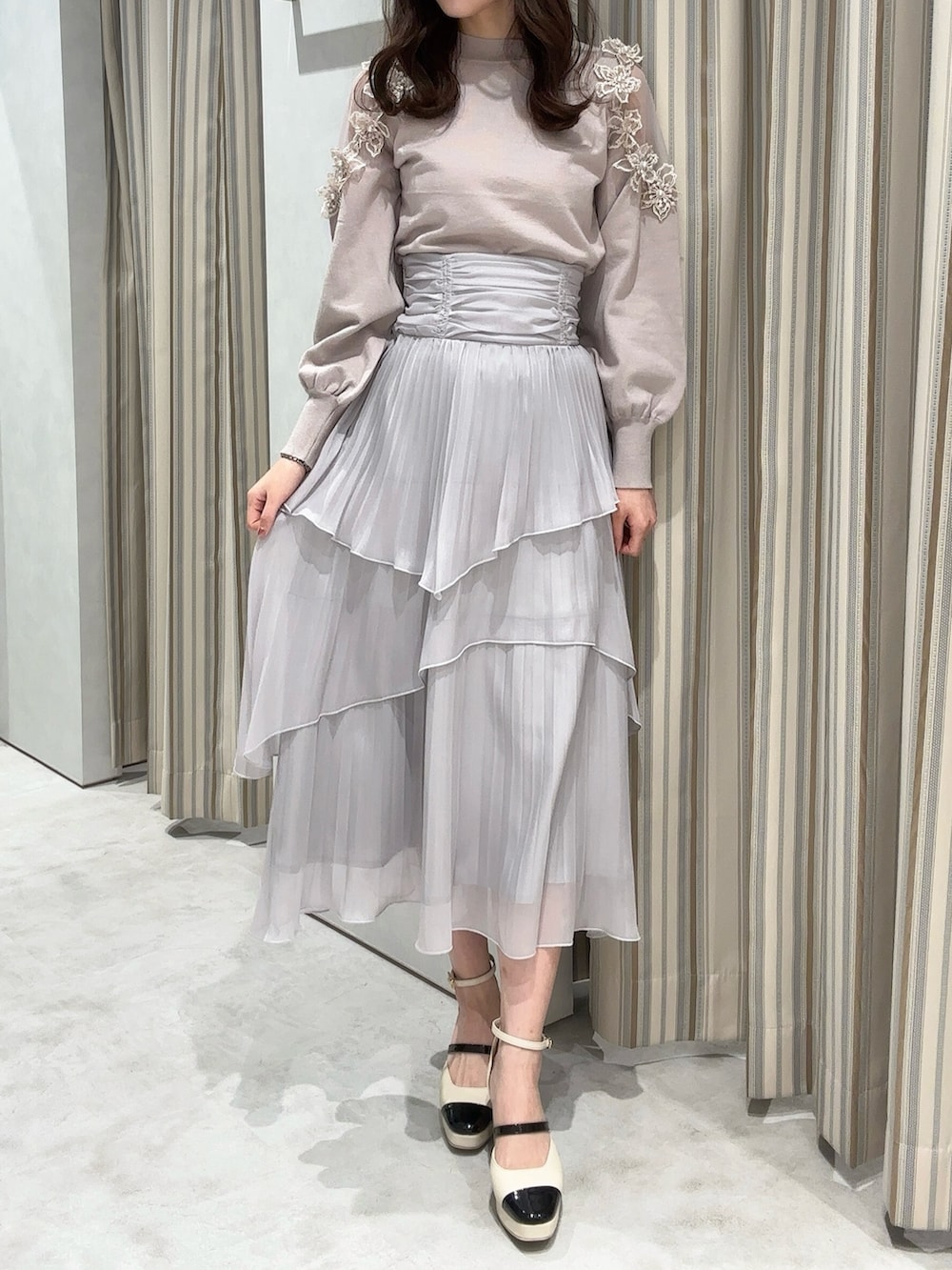 ピンク系のニット/セーター、グレー系のスカート、ベージュ系のパンプスを着用したレディースの冬コーディネートの2枚目の写真