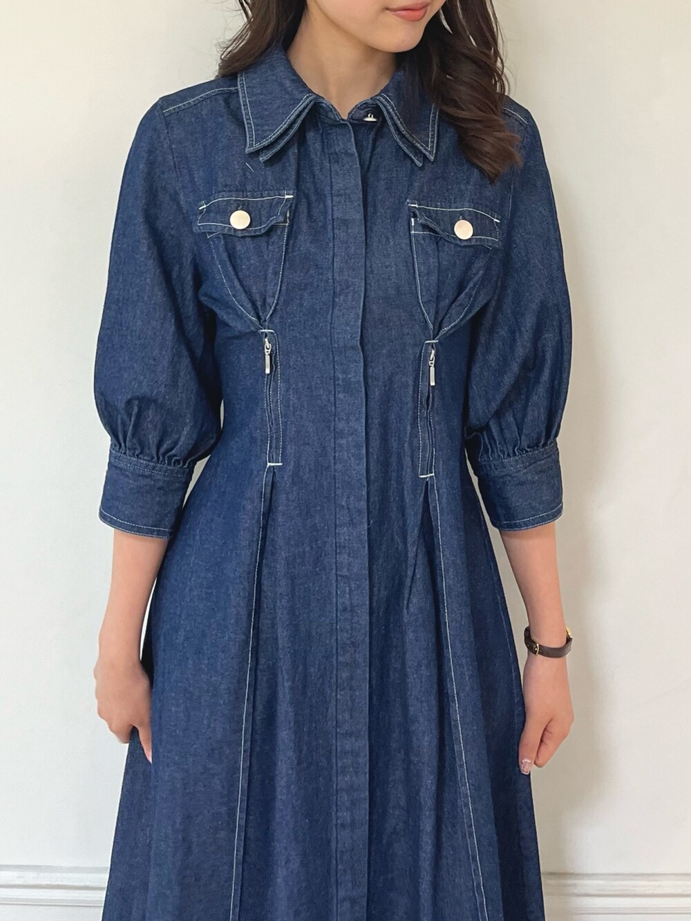 ブルー系のワンピース、ブラック系のパンプスを着用したレディースの冬コーディネートの6枚目の写真