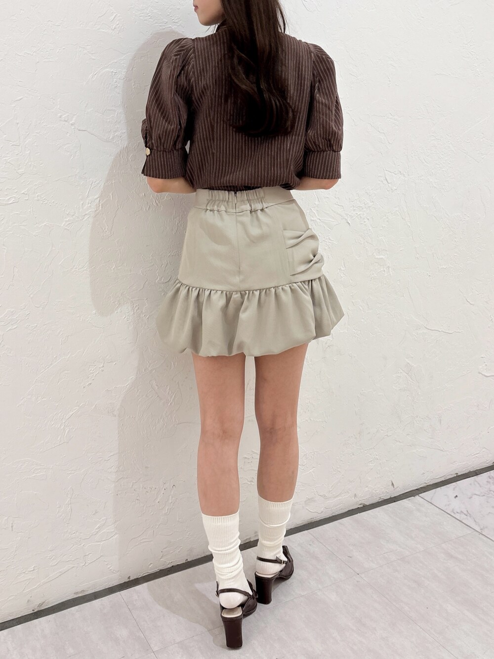 ブラウン系のシャツ/ブラウス、ベージュ系のスカート、ブラウン系のローファーを着用したレディースの夏コーディネートの6枚目の写真