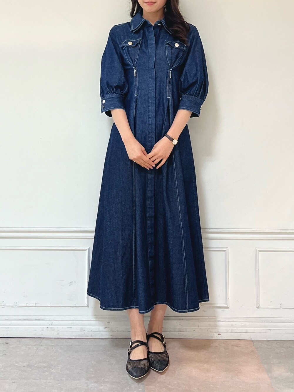 ブルー系のワンピース、ブラック系のパンプスを着用したレディースの冬コーディネートの2枚目の写真